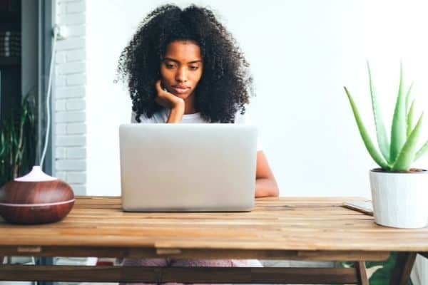 woman looking disappointed in front  of a laptop 