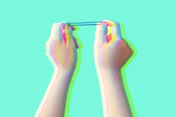 Woman's hands stretching a rubber band, symbolizing one's 'Rubber Band Era'.