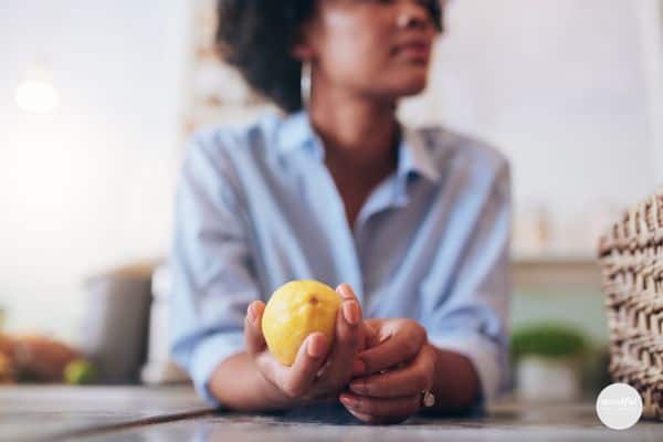 middle age woman holding a lemon, contemplating a career change