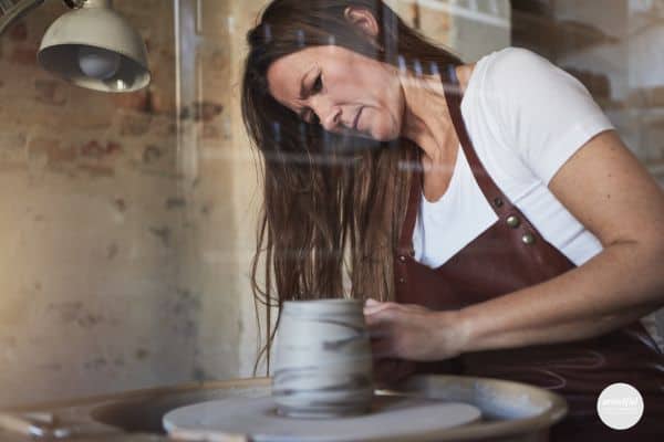 woman in her flow state, working on her pottery.