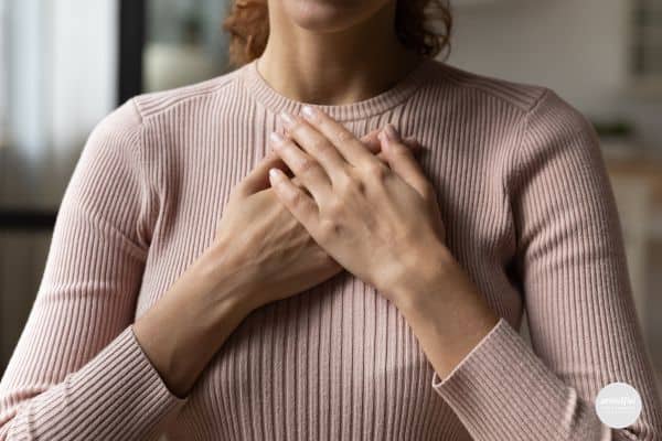 woman placing her hands over her chest, showing gratitude.