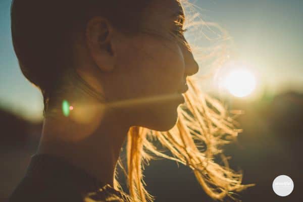 woman thinking positive thoughts looking at a sunset