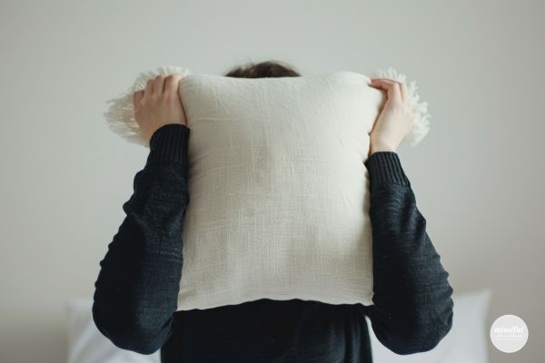 woman screaming into a pillow to instantly relieve stress.