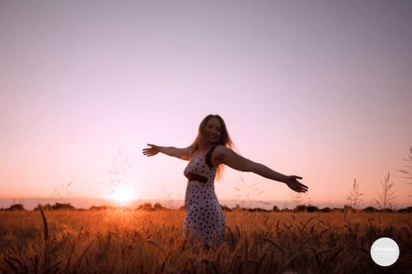 woman in a field feeling happy and at peace with her self-discovery journey