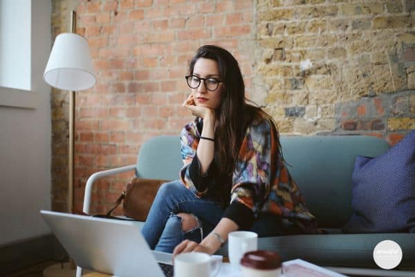 woman looking down, trying to overcome perfectionism with work.