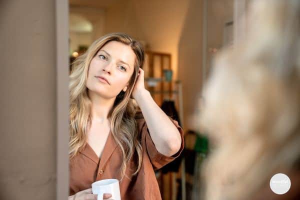 woman looking at herself in the mirror with positive self-talk