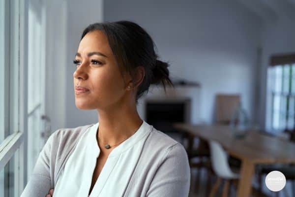 middle-age woman looking out the window feeling empowered.