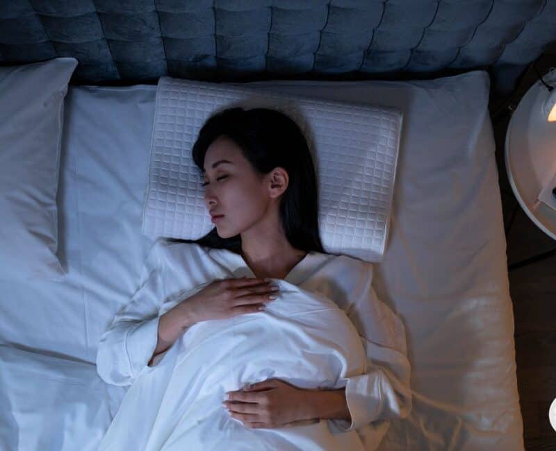 woman using breathing techniques to fall asleep at night.