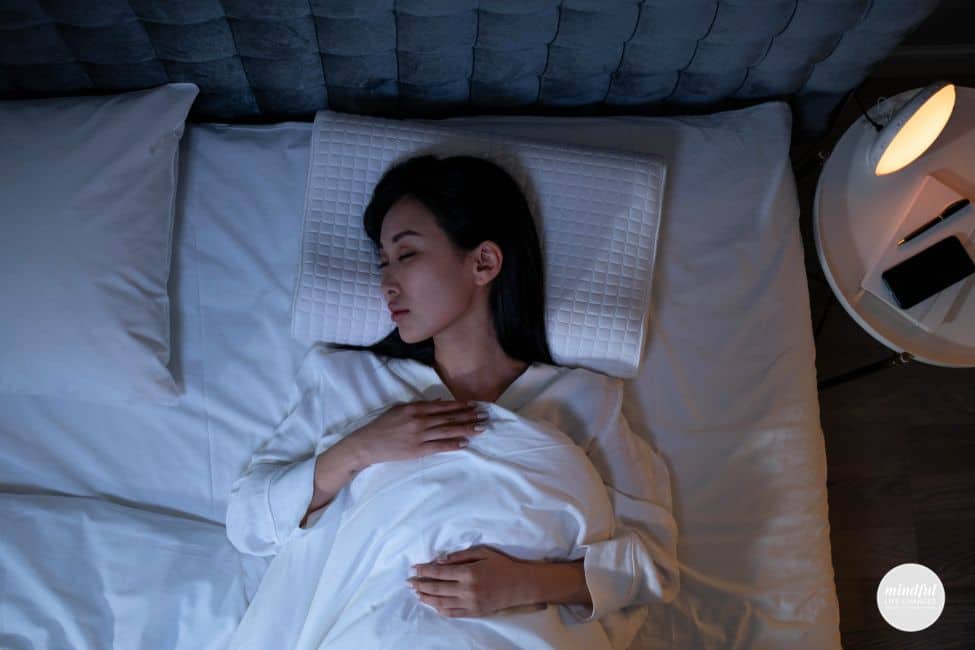 woman using breathing techniques to fall asleep at night.