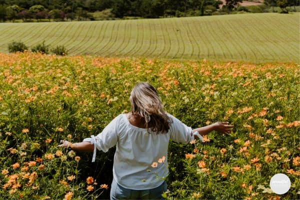 woman running in a field of yellow flowers, feeling her inner strength.